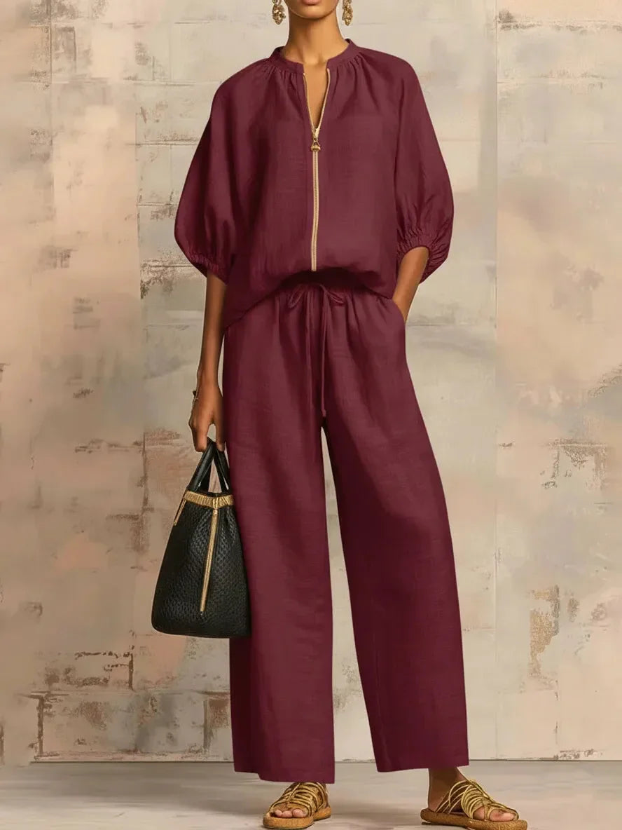 Burgundy linen jumpsuit with gold zipper, wide legs, and drawstring waist for sophisticated mature women